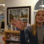 A student waving at the camera.