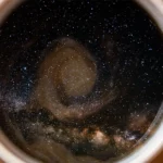 Stars and nebulas swirling within a coffee cup.