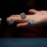 Dice rolling from an outstretched hand.