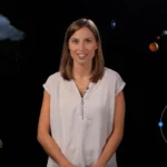An instructor surrounded by a cloud, a flower, planets and atom.