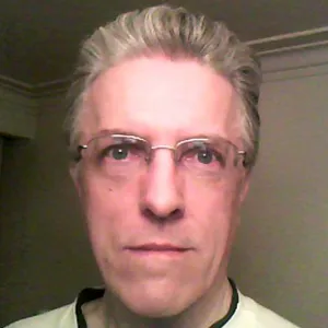 A man wearing glasses and a white shirt.