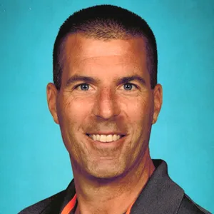 A man wearing a black shirt and orange tie.